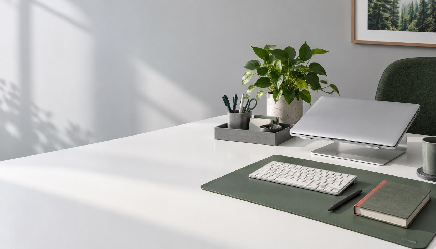 Concept workspace with a green desk mat, stationery organizer and passive laptop stand